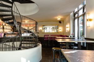 Blick auf einen großen Spiegel und die geschwungene Wendeltreppe