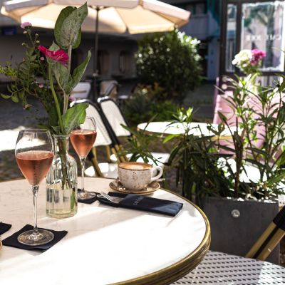 Mit Blumen und Pflanzen dekorierter Tisch mit Kaffee und Aperitif