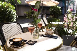 Mit Blumen und Pflanzen dekorierter Tisch mit Kaffee und Aperitif