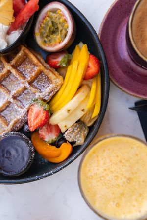 Waffel mit Obstsalat und frischen Früchten, Kaffee und Smoothie