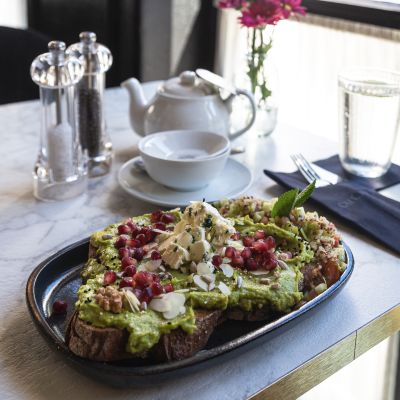 Feines Teeservice mit köstlichem Brot und smashed Avocado
