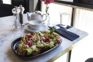 Feines Teeservice mit köstlichem Brot und smashed Avocado