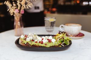 Brot mit Avocado, Feta und Granatapfelkernen, dazu eine Salatbeilage