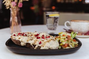 Brot mit hellem Aufstrich, Mandeln und Granatapfelkernen,dazu eine Salatbeilage