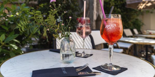 Zwei Aperitifs auf einem Tisch mit Blick auf ein Fachwerkhaus