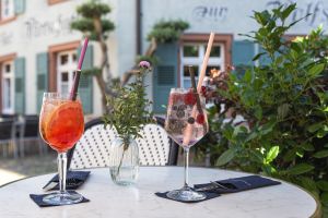 Zwei Aperitifs auf einem Tisch mit Blick auf ein Fachwerkhaus