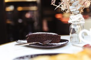 Ein Stück Schokoladenkuchen mit Puderzucker auf einem Teller