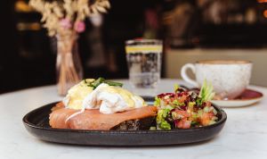 Pochierte Eier mit Lachs und Sauce Hollandaise auf Brot, dazu eine Salatbeilage
