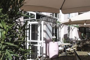 Mit Blumen und Pflanzen dekorierter Eingang zum Café Jolie
