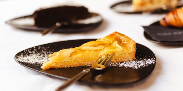 Kuchen, angerichtet auf schwarzen Tellern mit Besteck